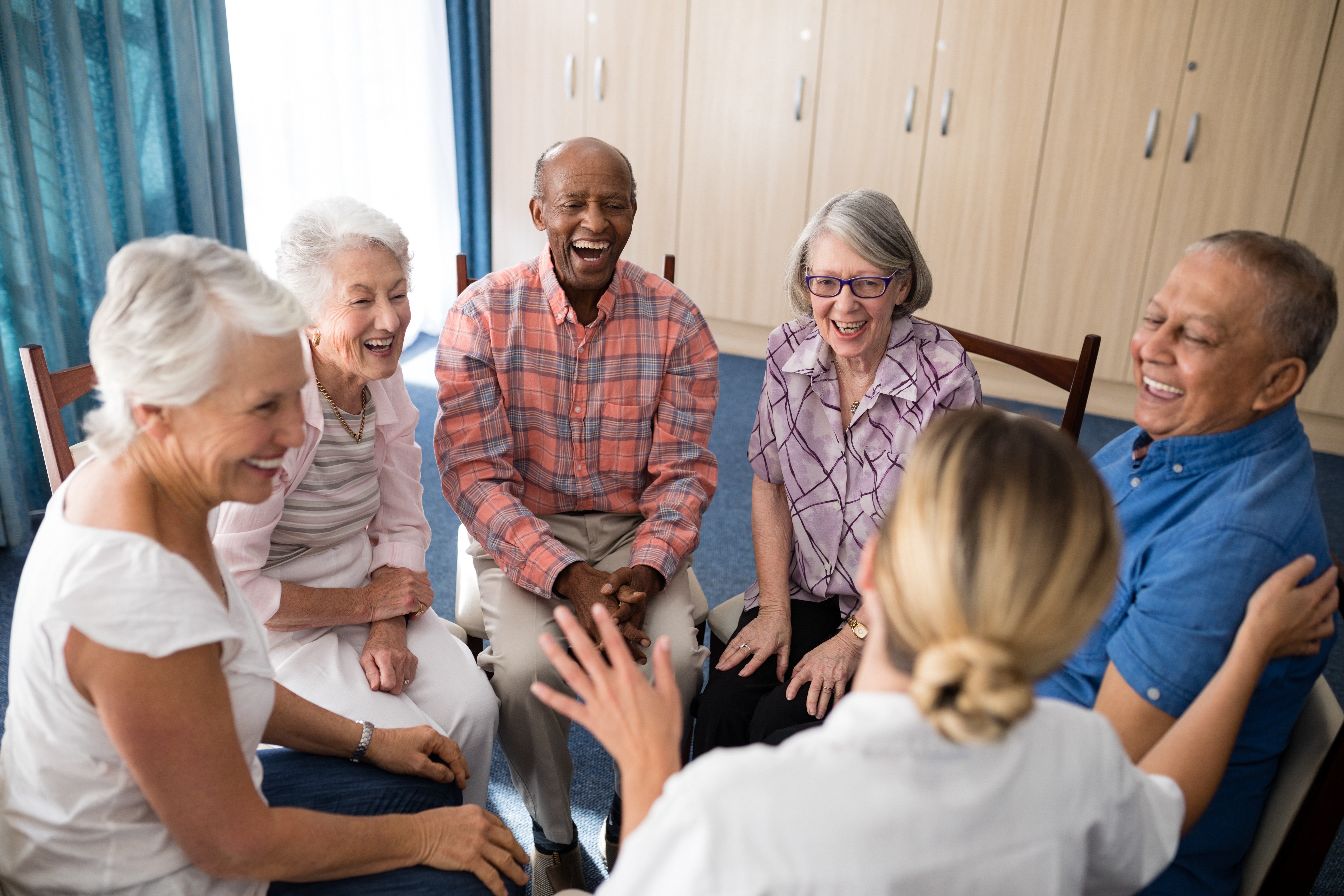 A group of elderly people listening to a healthcare professional.